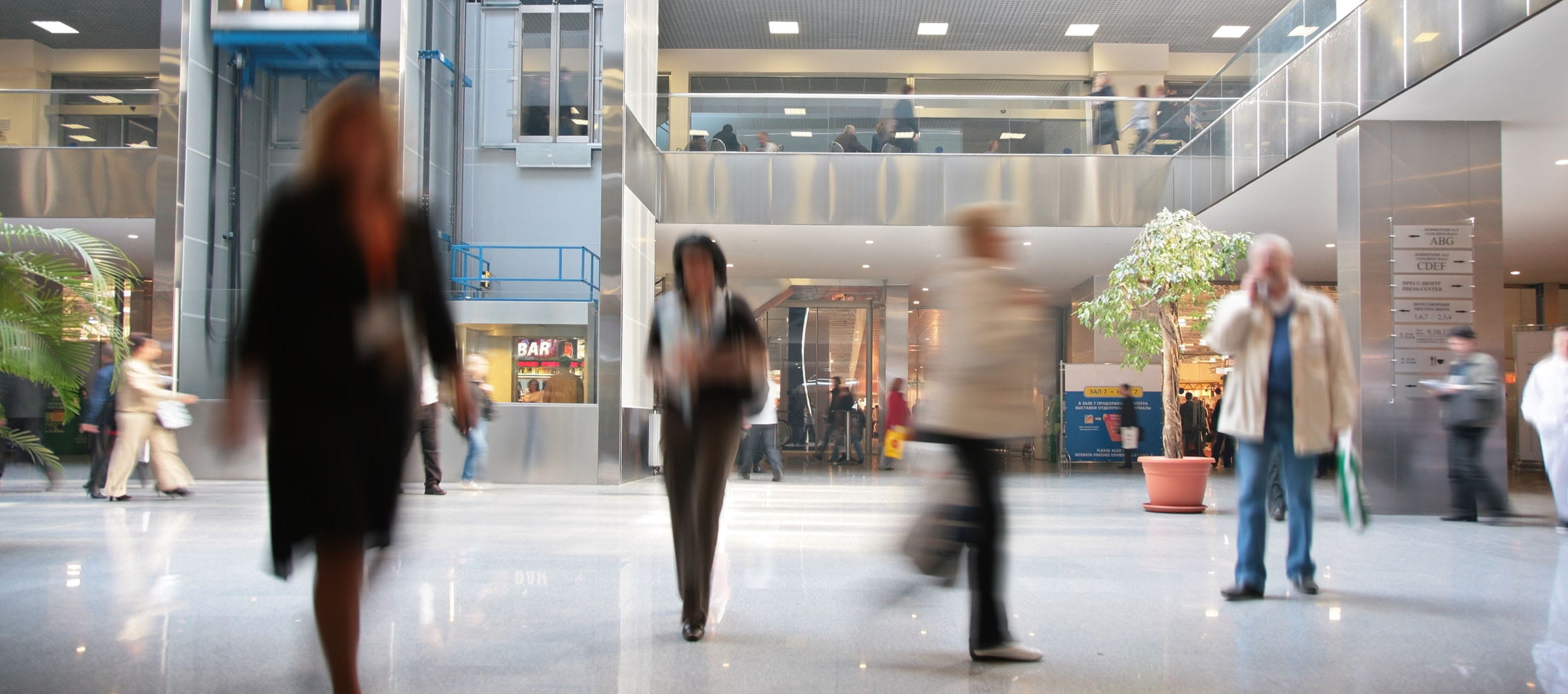 A diverse group moves through a modern and well-lit lobby