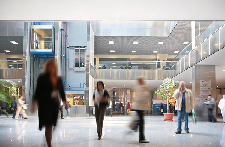 A diverse group moves through a modern and well-lit lobby