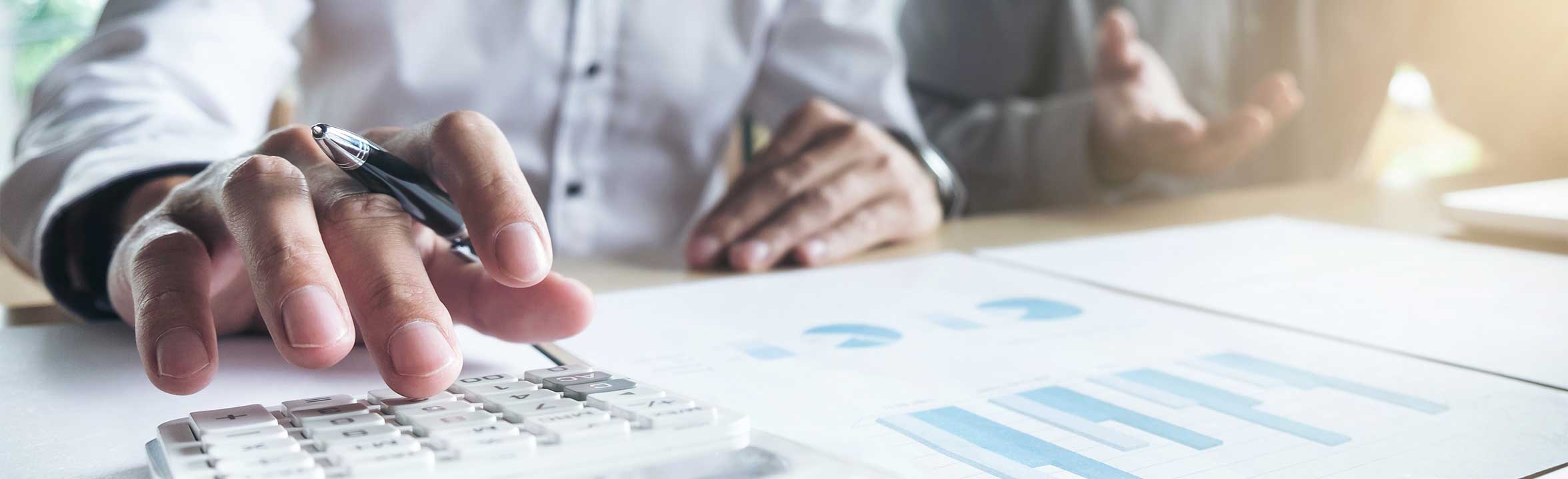 Two male colleagues calculate figures on the reports