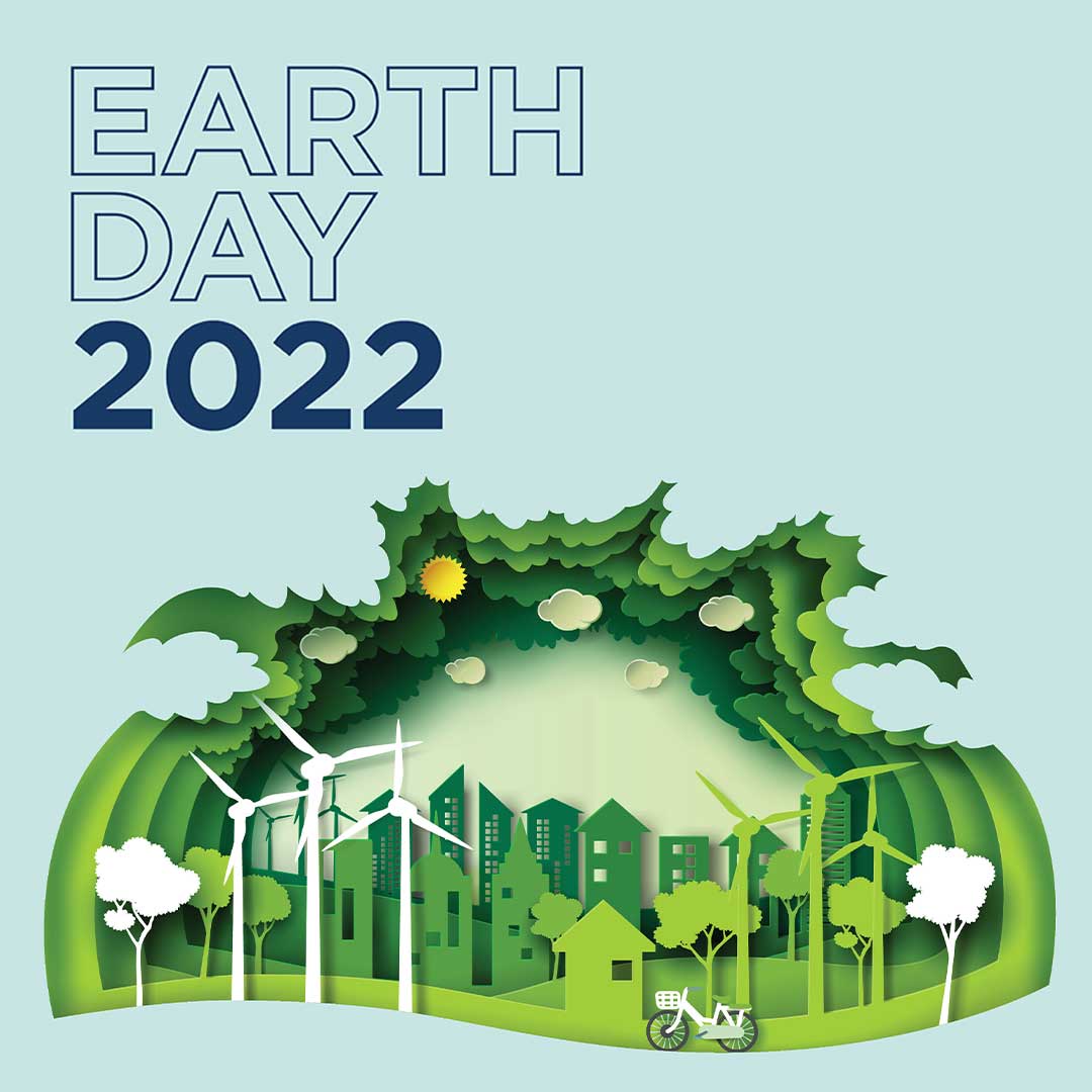 Illustration of a colorful paper cutout of a city scape with green house, trees, wind turbines and bicycles
