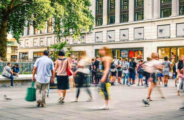 Busy motion blurred shopping street scene