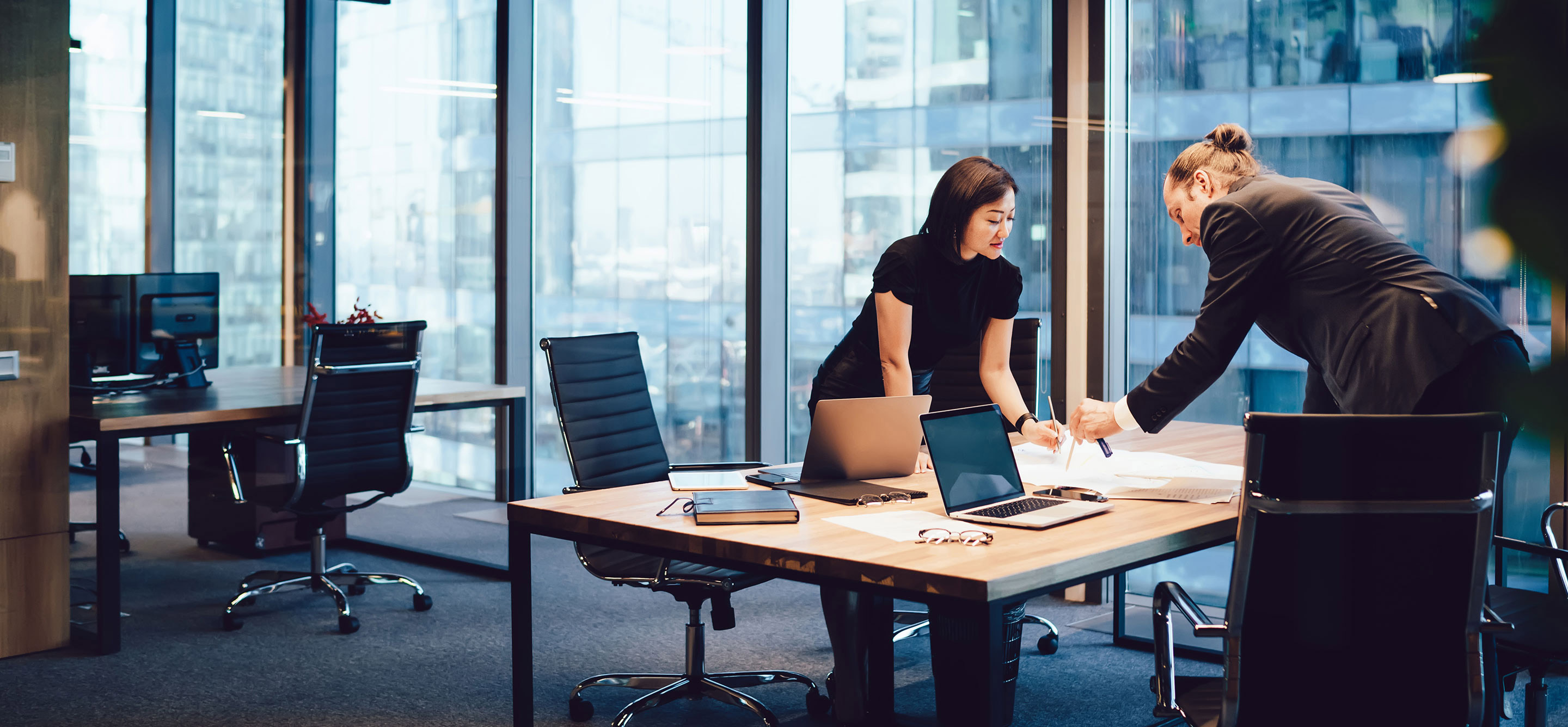 Multiethnische Kollegen arbeiten gemeinsam an einem Bauplan im Arbeitsraum