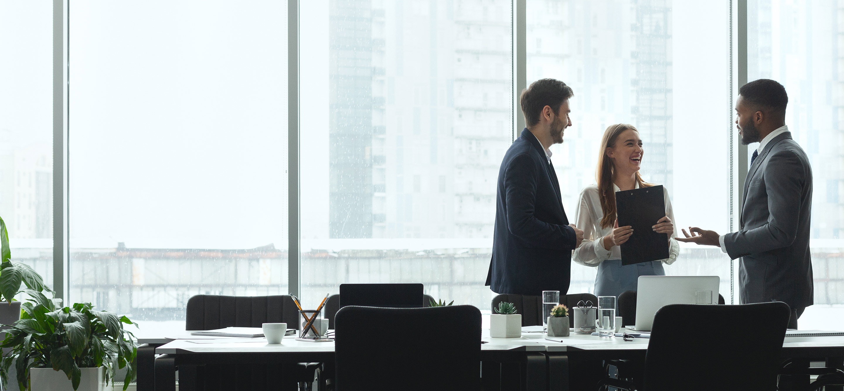Group of diverse business people talking in office with big windows