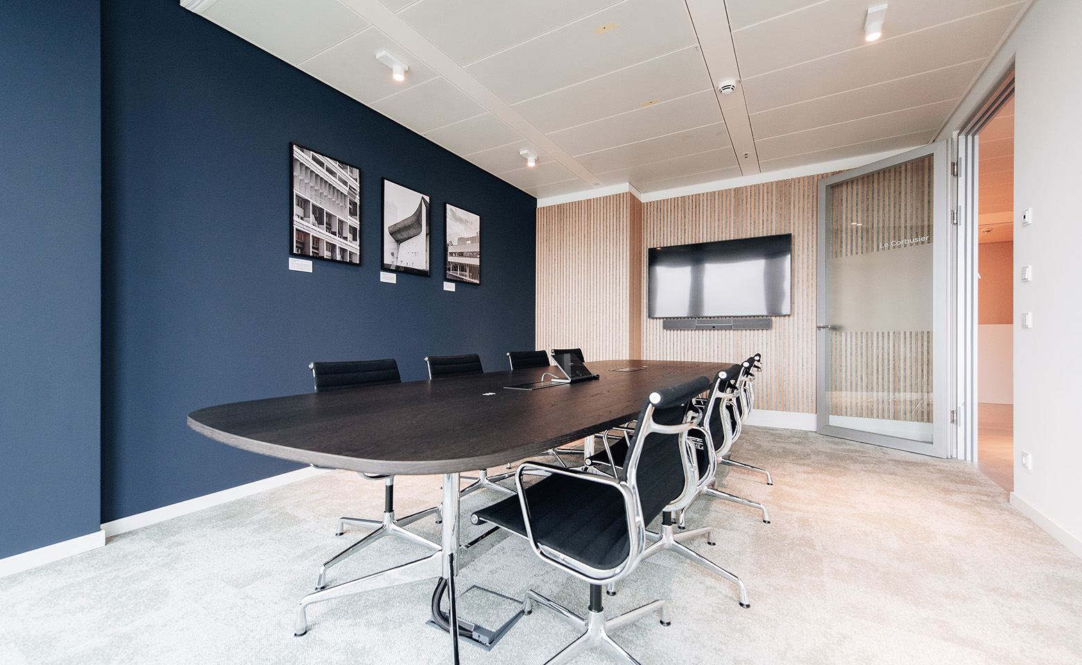 Meeting room with eight black office chairs and a big conferrence table